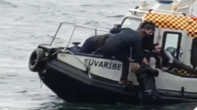 Denize düşen kadın, motorda çalışan bir kişi tarafından kurtarılarak botun üzerine çıkarıldı.