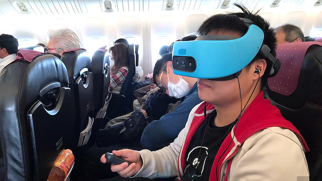 Bir yolcu kendi sanal gerçeklik gözlüğünü kullanıyor.