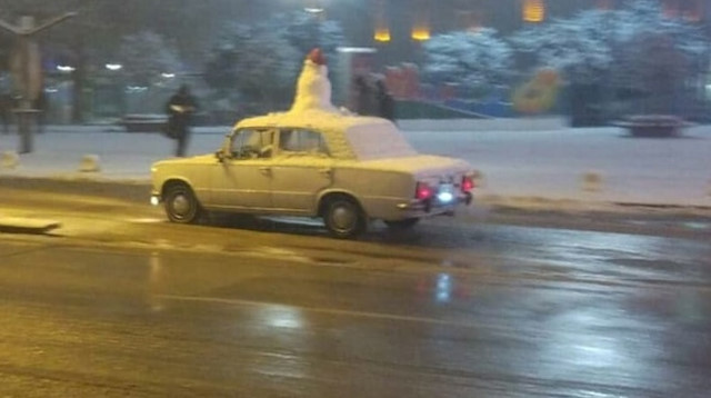 Aracının üzerine koyduğu kardan adamla şehir turu attı.