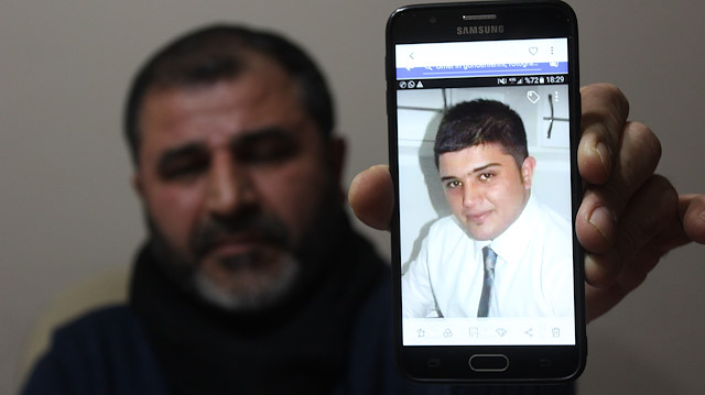Acılı baba, hayatını kaybeden oğlunun fotoğrafını cep telefonundan gösterirken.
