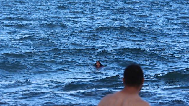 Suya atlayan kadına yardım etmek isteyen sahildeki vatandaşlar dalga ve akıntı nedeniyle olayı sadece kıyıdan izleyebildi.