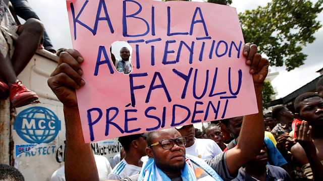 Supporters of the runner-up in Democratic Republic of Congo's presidential election, Martin Fayulu hold a sign before a political rally in Kinshasa, Democratic Republic of Congo.