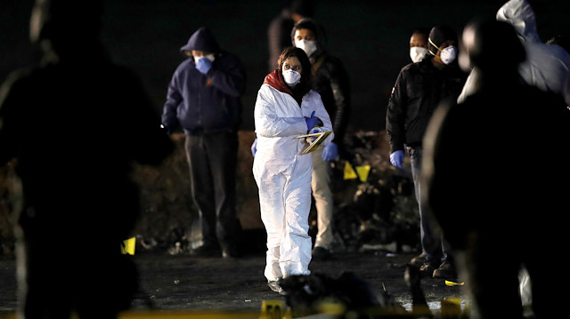 A forensic technician works at the site where a fuel pipeline ruptured