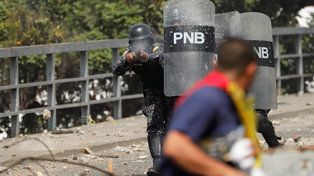 Venezuela'da protesto gösterilerinde polis bir vatandaşa müdahale ediyor. (Fotoğraf: Reuters)