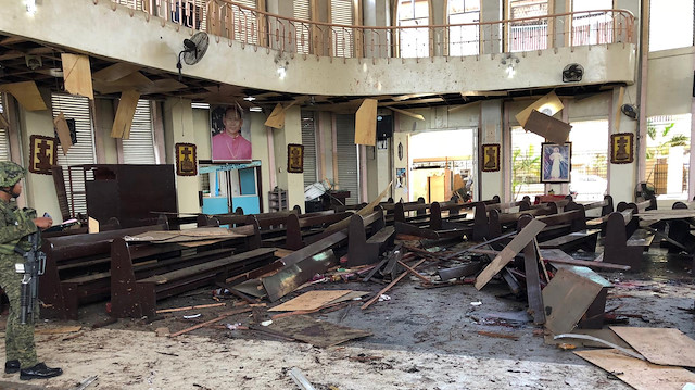 A Philippine Army member inspects the damage inside a church after a bombing attack