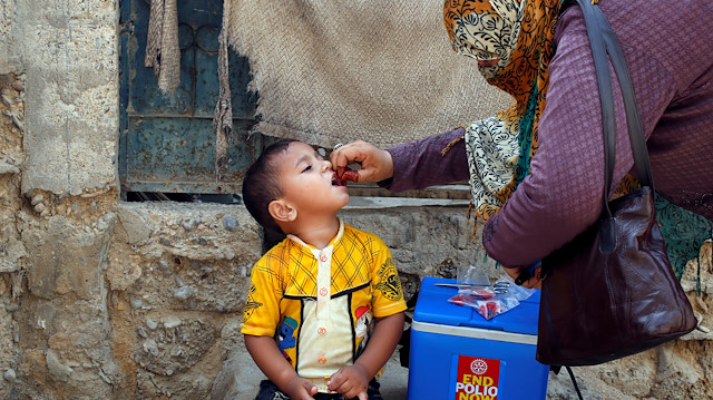 A boy receives polio vaccine drops, during an anti-polio campaign
