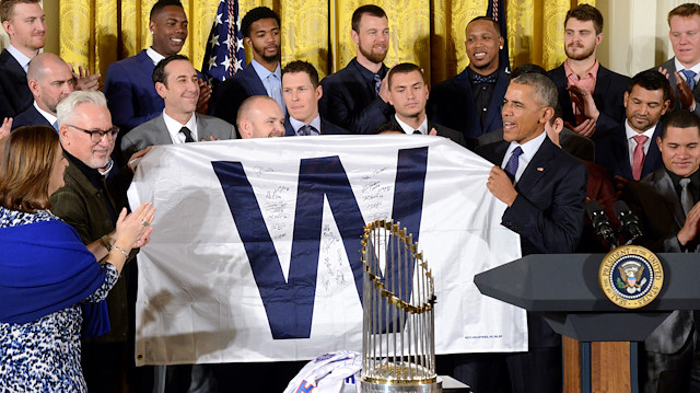 President Barack Obama holds up a traditional "W" pennant, for a "Win", along with Manager Joe Ricketts