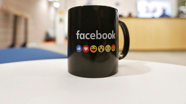  The Facebook logo and emoticons are seen on a coffee mug 