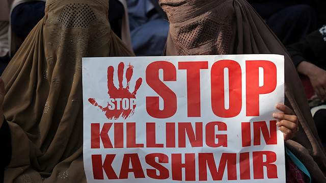 Keşmirli bir kadının protesto gösterisinde taşıdığı pankart: 'Keşmir'de katliamı durdurun' 