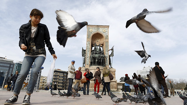 Local and foreign tourists stroll at Taksim square in central Istanbul, Turkey