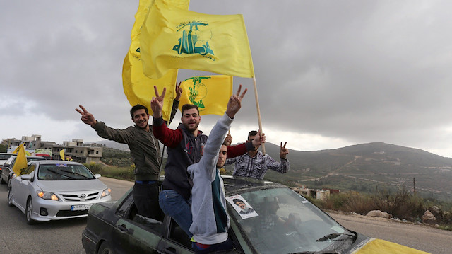 File photo: Supporters of Lebanon's Hezbollah leader Sayyed Hassan Nasrallah gesture as they hold Hezbollah flags 