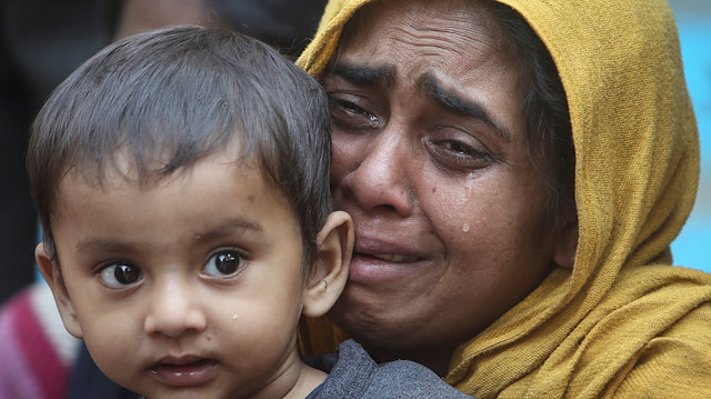 A Rohingya Muslim woman cries as she holds her daughter after they were detained