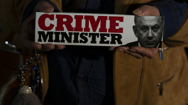 Tel Aviv'de düzenlenen protestoda taşınan pankart: Suç Başbakanı. 