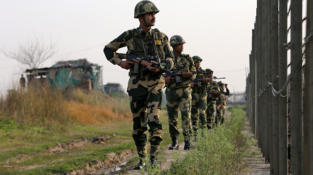 India's Border Security Force (BSF) soldiers patrol along the fenced border with Pakistan i