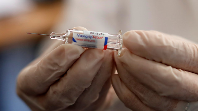 A doctor holds a syringe as part of the start of the seasonal influenza vaccination campaign 