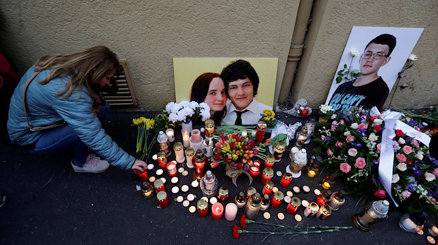 A woman kneels by a memorial on the first anniversary of the murder of the investigative reporter Jan Kuciak and his fiancee Martina Kusnirova in Bratislava, Slovakia, February 21, 2019