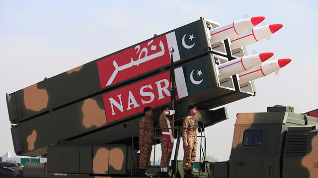 Pakistani military personnel stand beside short-range Surface to Surface Missile NASR 