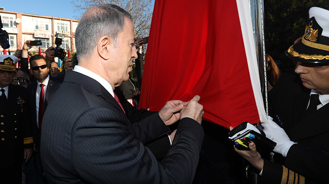 Bakan Akar, altın madalyayı Türk bayrağına toka etti.