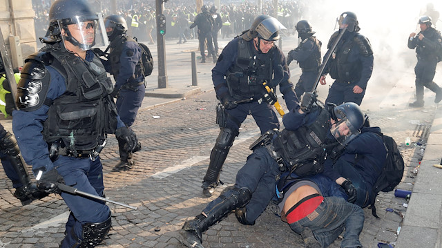 French riot police detain a protester during a demonstration by the "yellow vests" movement