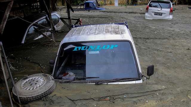 Cars are submerged in mud following a flash flood in Sentani, Papua, Indonesia