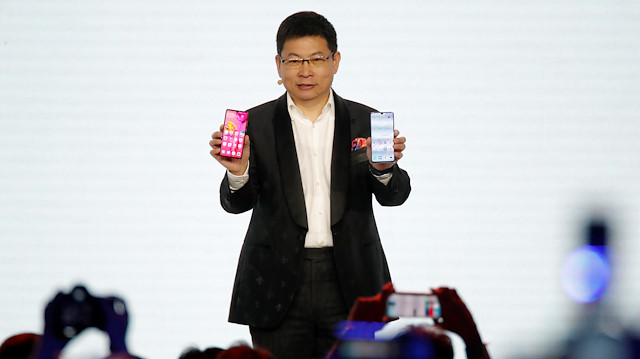 Huawei CEO'su Richard Yu, Paris'teki etkinlikte P30 ve P30 Pro'yu elinde tutuyor.