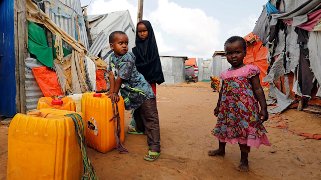 File photo: Somali children stand outside their makeshift shelter at a camp for the internally displaced people outside Mogadishu