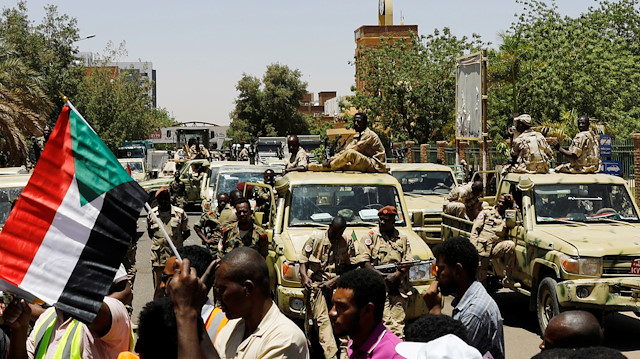 Sudanese demonstrators chant slogan in front of security forces during a protest in Khartoum