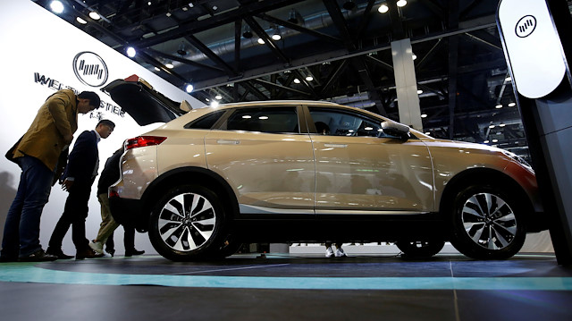 FILE PHOTO: People look at a Weltmeister electric sport utility vehicle (SUV) by WM Motor at the IEEV New Energy Vehicles Exhibition in Beijing, China October 18, 2018. Picture taken October 18, 2018. REUTERS/Thomas Peter/File Photo

