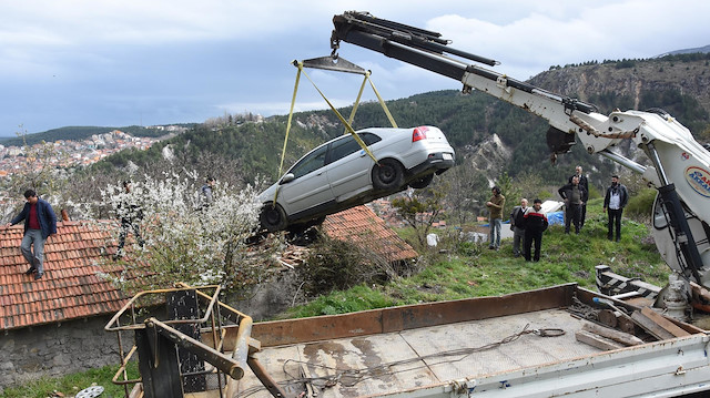 Çatıya uçan araba çekici yardımıyla bulunduğu yerden kaldırıldı.