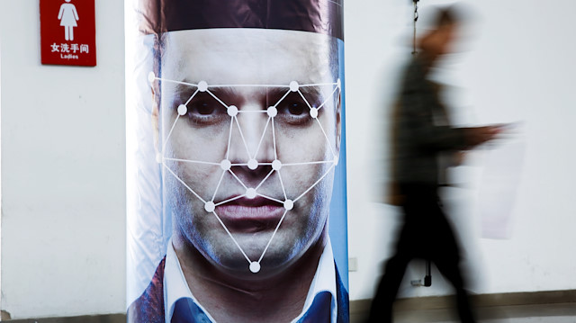 File photo: A man walks past a poster simulating facial recognition software at the Security China 2018 exhibition on public safety and security in Beijing, China 