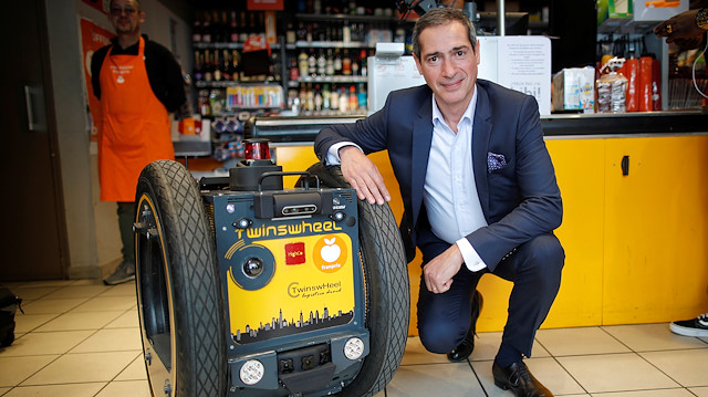 Chief Executive Ofﬁcer of Franprix Jean-Paul Mochet poses alongside an autonomous robot, shaped and inspired by Star Wars R2D2, in the launch of a test for the delivery of groceries by Franprix supermarket chain in the 13th district of Paris, France, April 17, 2019. 