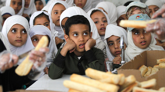 File photo: Yemeni students wait to get free food from a local charity at a school in Sanaa