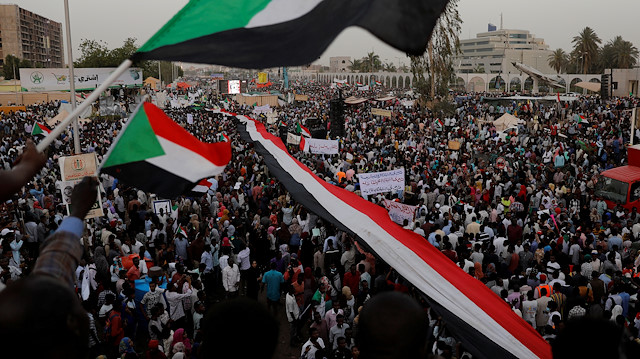 Thousands of protesters wave Sudanese flags, hold banners and chant slogans during a demonstration in front of the Defence Ministry in Khartoum, Sudan, April 18, 2019.
