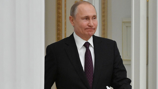 Russian President Vladimir Putin enters a hall to meet French business leaders