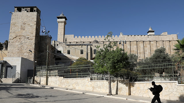 An Israeli soldier walks past Ibrahimi Mosque