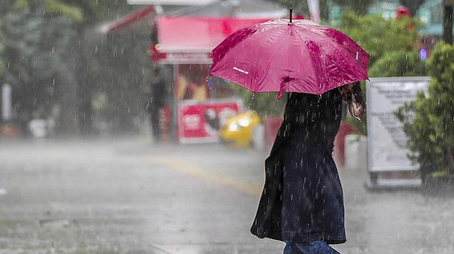 Sağanak altında şemsiye ile bekleyen vatandaş.