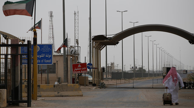 A Kuwaiti passenger is seen heading to Kuwait at the border gate between Iraq and Kuwait