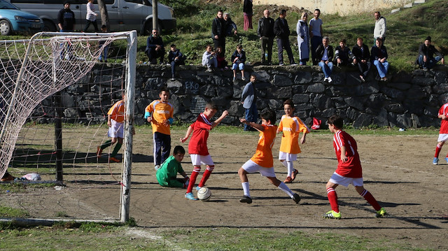 Toprak sahada futbol oynayan çocuklar. Fotoğraf: Arşiv.