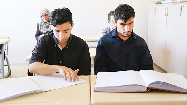 Parmak uçlarıyla hissederek Kur'an-ı Kerim okuyan engelliler.