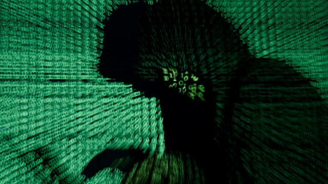 FILE PHOTO: A man holds a laptop computer as cyber code is projected on him in this illustration picture taken on May 13, 2017. Capitalizing on spying tools believed to have been developed by the U.S. National Security Agency, hackers staged a cyber assault with a self-spreading malware that has infected tens of thousands of computers in nearly 100 countries. REUTERS/Kacper Pempel/Illustration/File Photo

