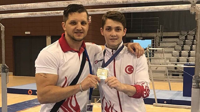 File photo: Turkish male gymnast Sercan Demir (R)