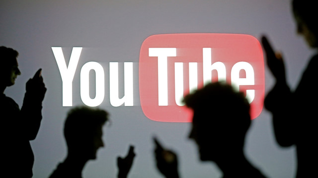 People are silhouetted in front of Youtube logo