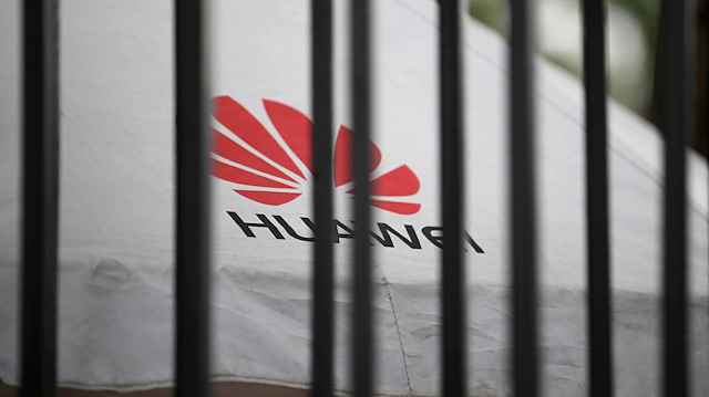 A Huawei logo is seen outside the fence at its headquarters in Shenzhen
