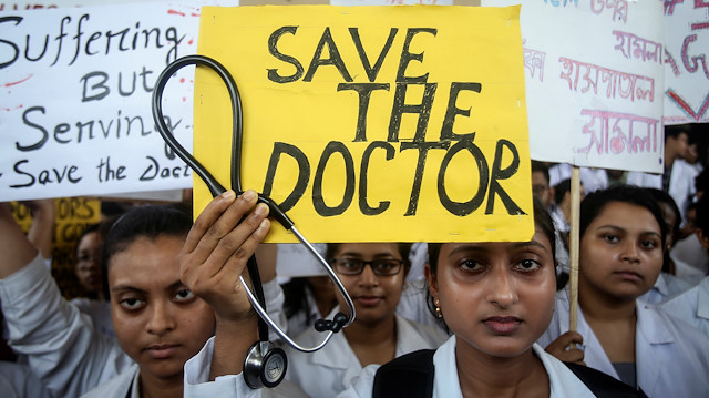 A doctor holds a placard at a government hospital during a strike demanding security after the recent assaults on doctors by the patients' relatives, in Agartala, India, June 14, 2019. 