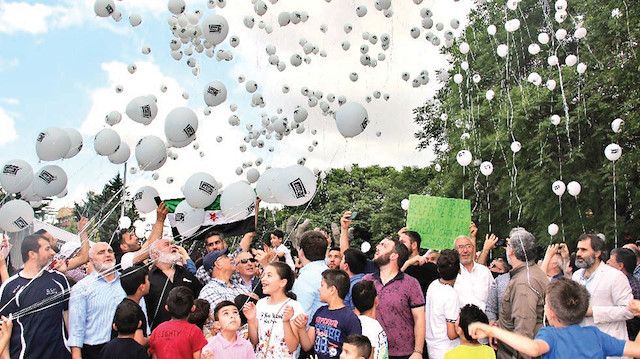Ellerindeki balonları gökyüzüne bırakan kişiler, Suriye’de vahşetin artık bitmesi gerektiğini belirterek rejime ‘Katliama son ver’ çağrısı yaptı