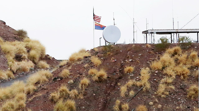An Arizona flag and the United States flag fly above the Arizona National Guard Papago Park 
