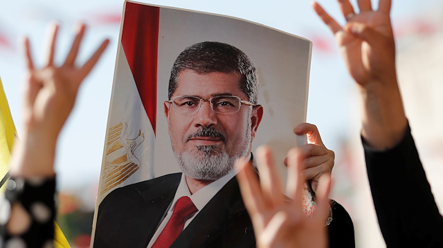 People flash Rabia signs as they hold a picture of former Egyptian president Mohamed Mursi during a symbolic funeral prayer at the courtyard of Fatih Mosque in Istanbul, Turkey, June 18, 2019. REUTERS/Murad Sezer NO RESALES. 

