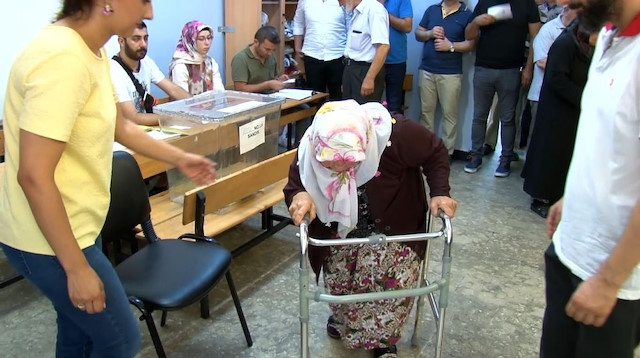 71 yaşındaki bir kadın yürüteç ile oy kullanmaya gelerek vatandaşlık görevini yerine getirdi.