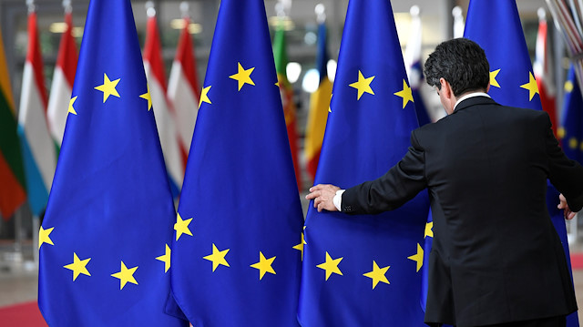 File photo: A staff member sets up EU flags ahead of a European Union leaders summit 