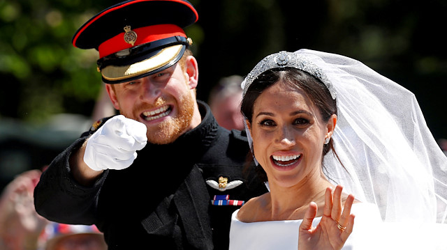 FILE PHOTO: Britain's Prince Harry gestures next to his wife Meghan as they ride a horse-drawn carriage after their wedding ceremony at St George's Chapel in Windsor Castle in Windsor, Britain, May 19, 2018. REUTERS/Damir Sagolj/File Photo

